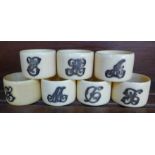 Seven napkin rings with applied white metal initials