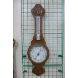 A carved oak aneroid barometer