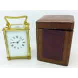 A brass and four glass sided carriage clock in a leather covered case,