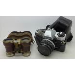 An Olympus OM10 35mm camera and a pair of binoculars marked The Touring Club,