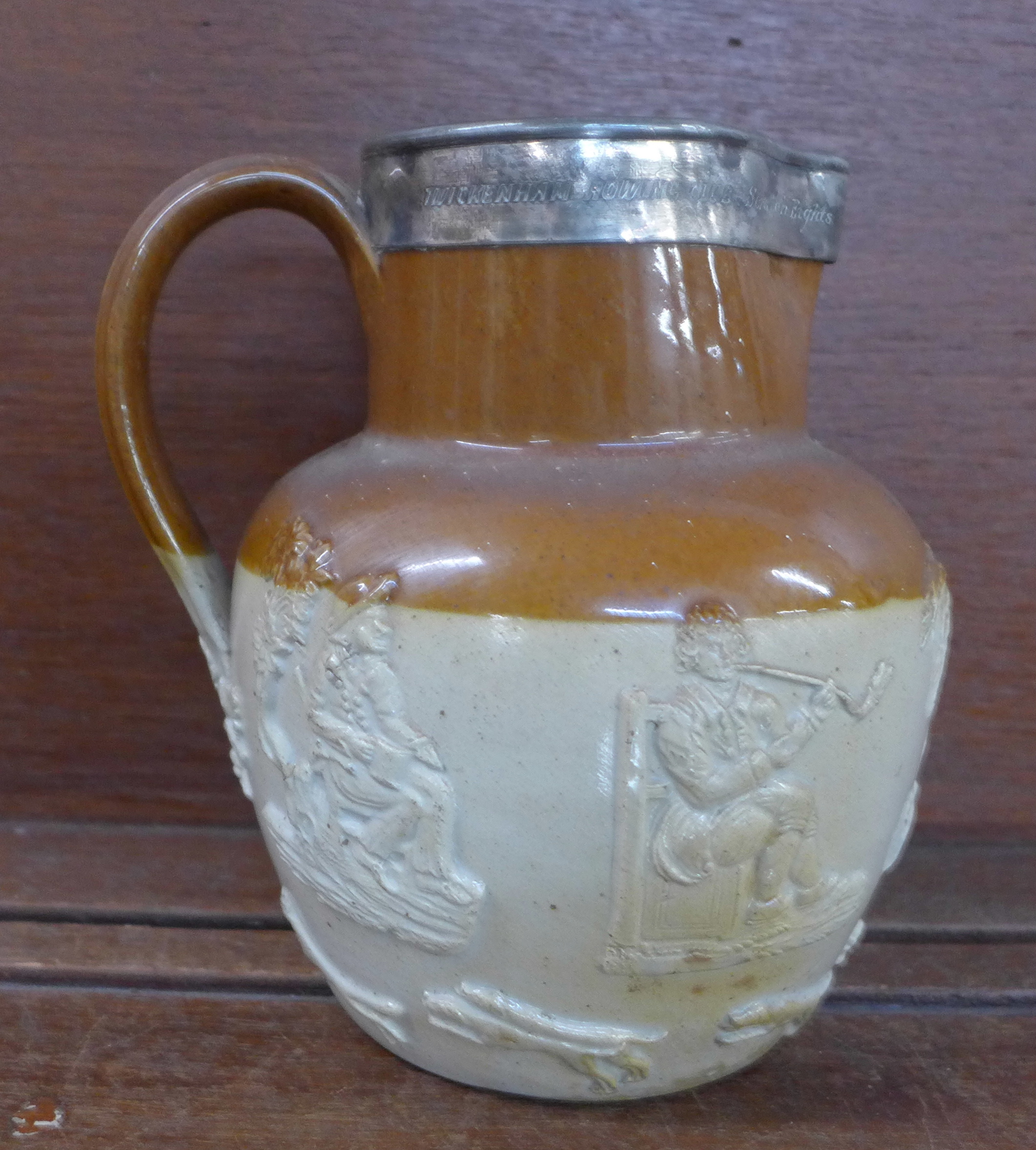 A 19th Century saltglaze jug with plated rim, with inscription,