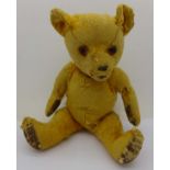 A straw filled jointed Teddy bear,