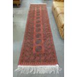 A Middle-Eastern red ground runner rug