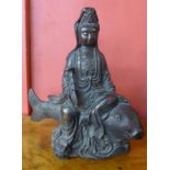 A Chinese bronze figure of a deity seated on a carp