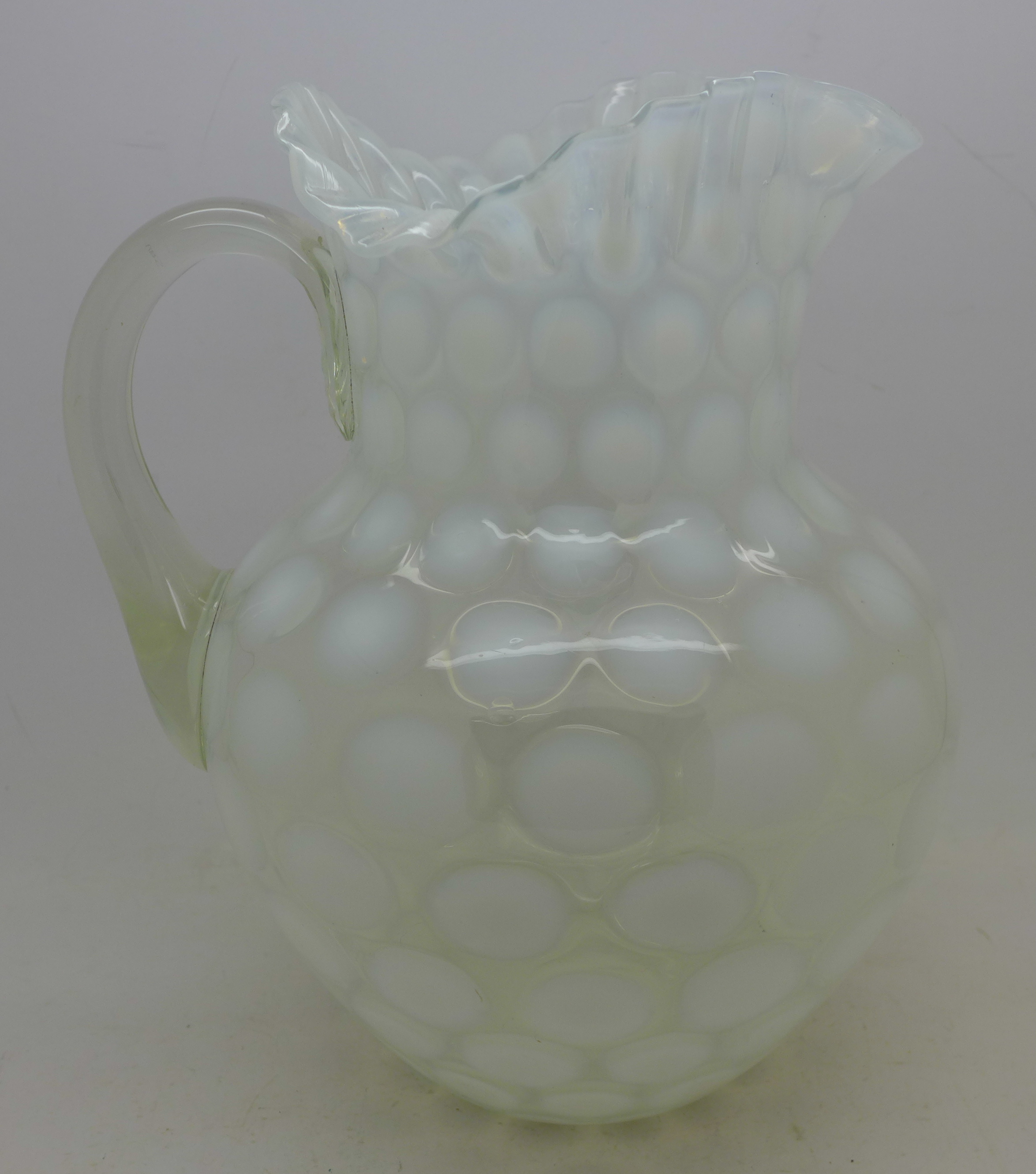 A glass 'coin dot' jug,