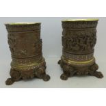 A pair of copper plated and brass lined candle holders with embossed tavern scenes,