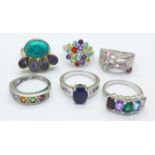 Six silver and multi-coloured stone set rings