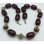 A set of sherry amber beads interspersed with white metal mounts, test as silver, 152.