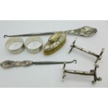 A pair of silver napkin rings, two silver handled button hooks,