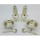 A pair of silver pepper pots, Walker and Hall, and a pair of silver salts and spoons,