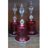 Three Victorian graduated cranberry glass bells,