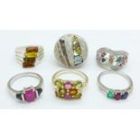 Six silver and multi-coloured stone set rings