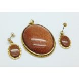 A large gold stone set pendant and similar earrings,