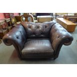 A brown leather Chesterfield lovers chair