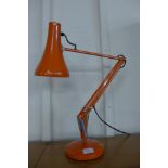 An orange anglepoise desk lamp