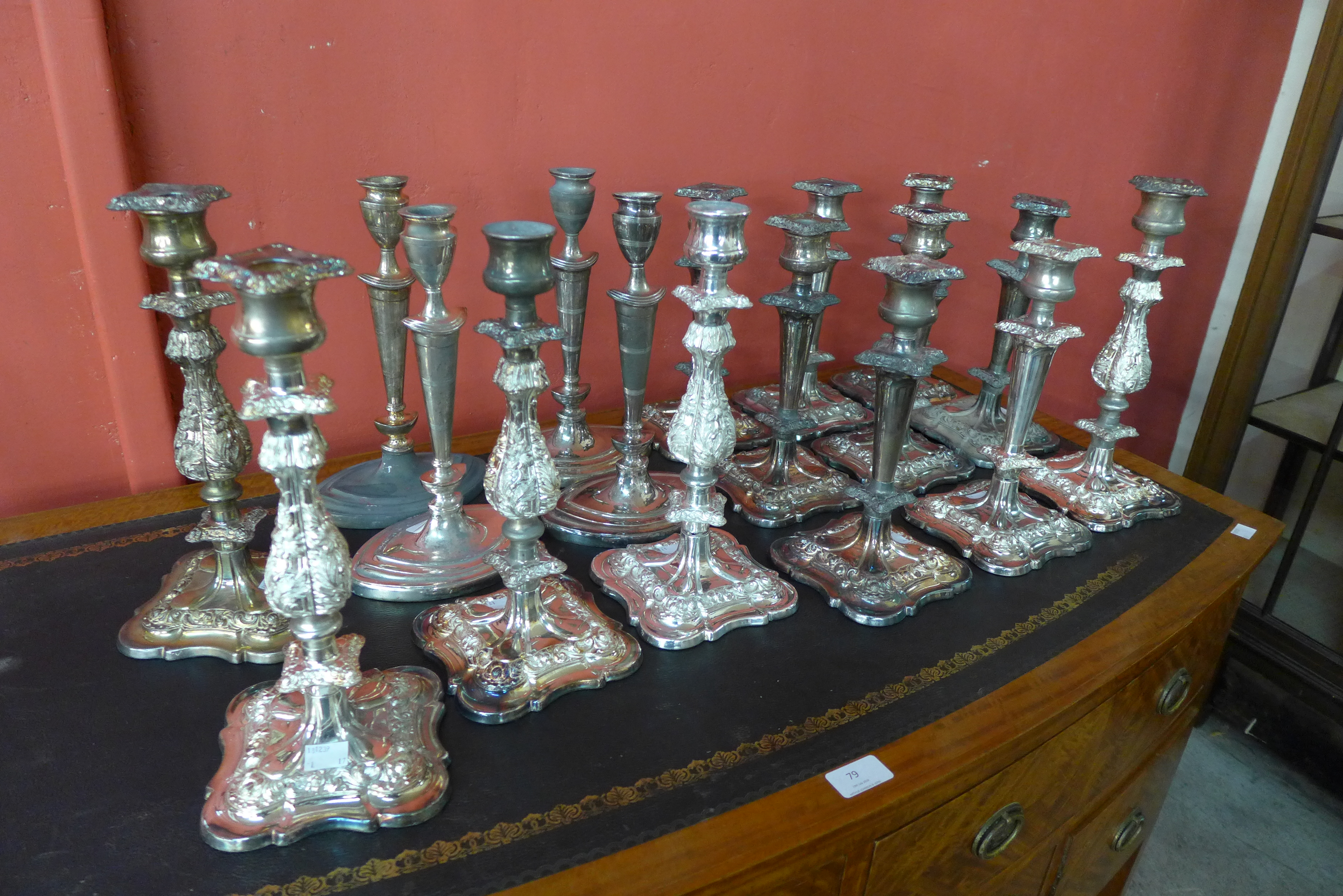 Seventeen silver plated candlesticks (some lacking sconces)