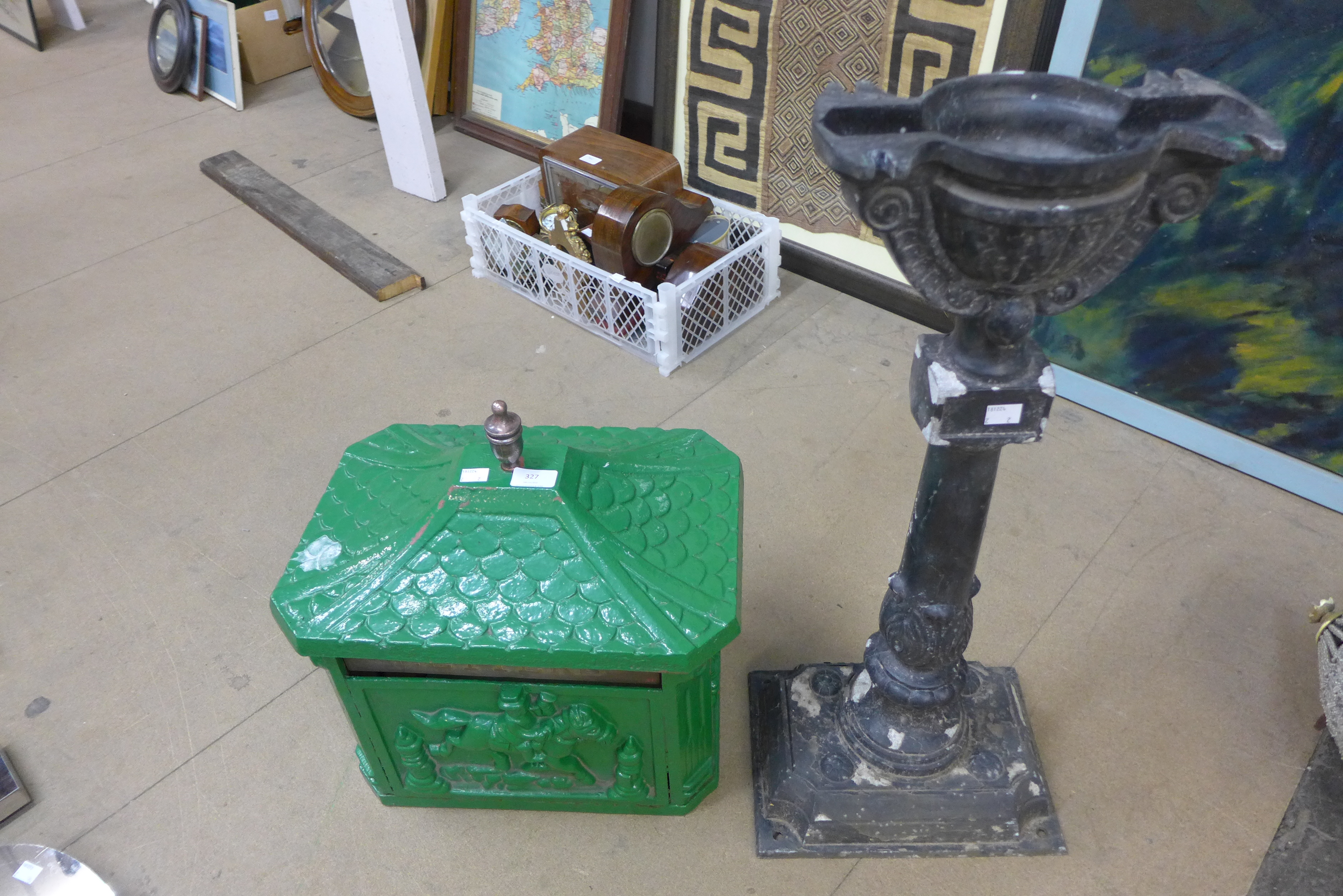 A painted cast iron letter box and associated stand
