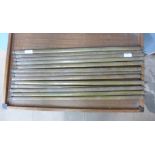 A collection of brass stair rods