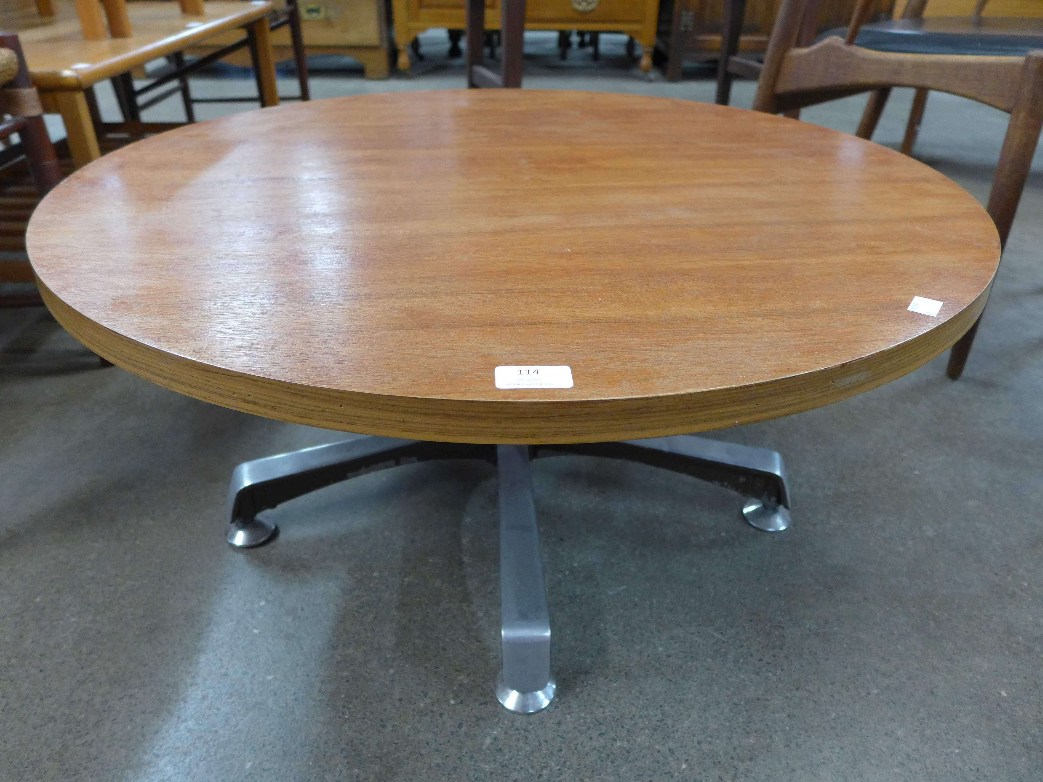 A teak circular coffee table on chrome stand