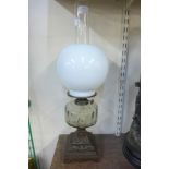 An oil lamp with metal base and glass reservoir