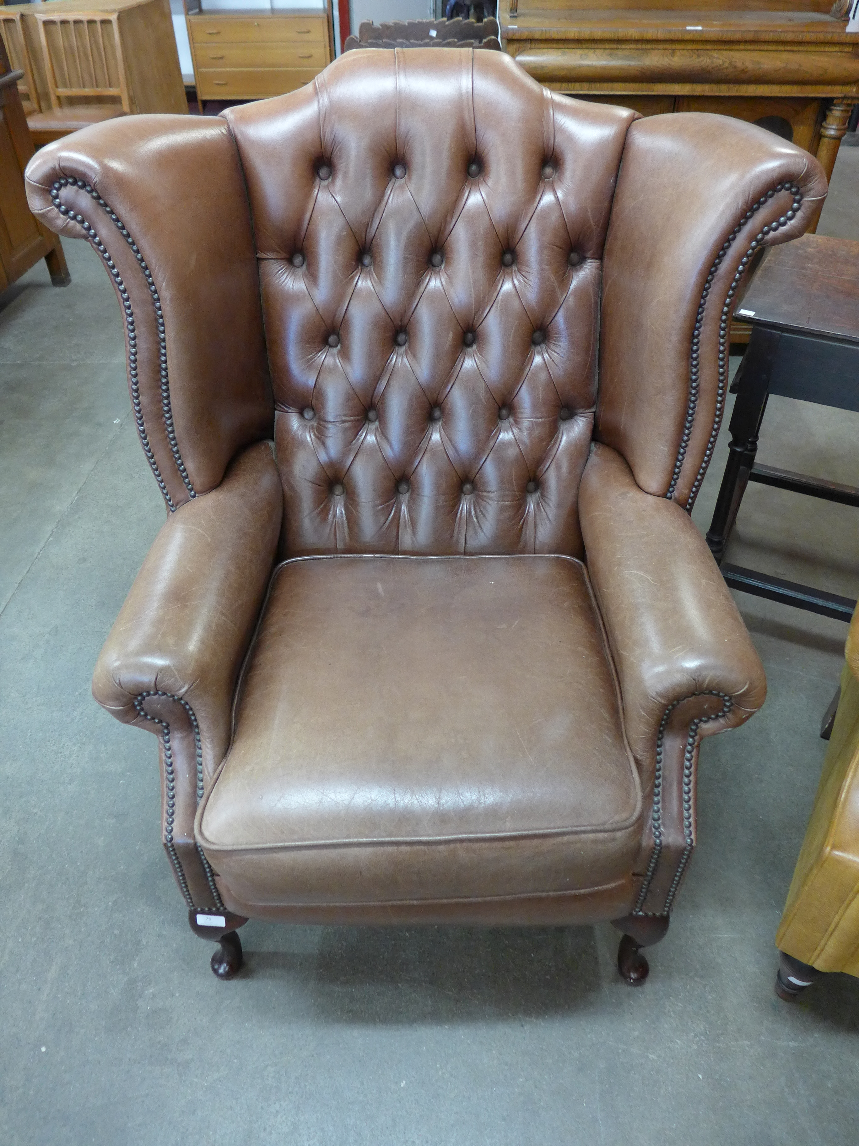 A brown leather Chesterfield wingback armchair