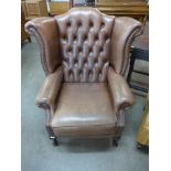 A brown leather Chesterfield wingback armchair