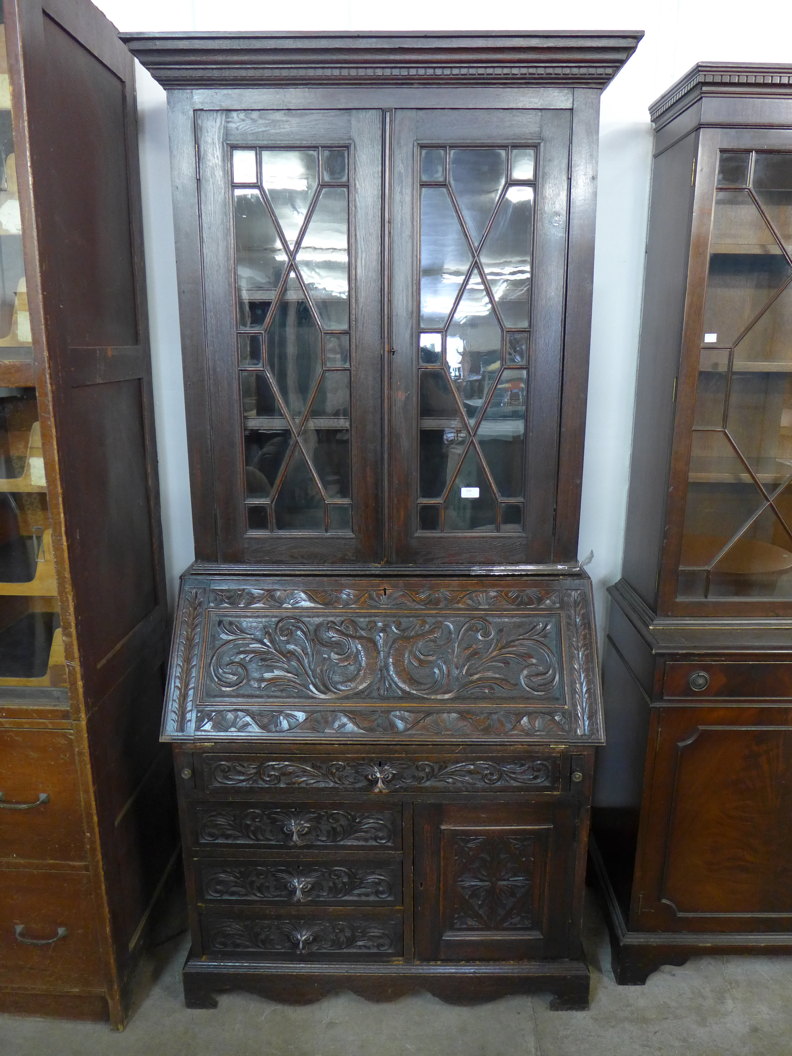 A Victorian Jacobean Revival carved oak bureau bookcase