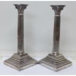 A pair of silver plated candlesticks with Corinthian columns,