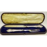 A cased knife and fork with silver covered handles