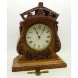 A carved oak cased mantel timepiece,