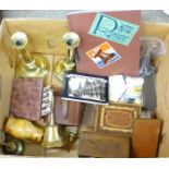 A pair of brass candlesticks, brass bells, a pair of field glasses, two wooden boxes, pin cushion,