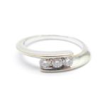 A white metal set three stone diamond ring, 2.