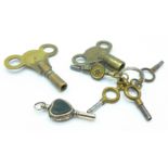 A yellow metal watch key and six other keys