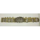 An Eastern white metal belt with large buckle and twenty-two engraved panels,