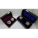 A pair of Victorian silver napkin rings and a pair of silver salts and spoons, both cased,