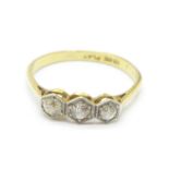 An 18ct gold, three stone diamond ring, 1.