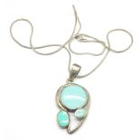A large silver and turquoise colour pendant on chain