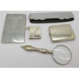 A 925 silver stamp holder, a plated matchbook holder, a magnifying glass, a notebook, etc.