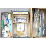 Laboratory equipment including a Bunsen burner, thermometers, glass test tubes, goggles, etc.