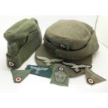 A German 1937 field cap and a model 1943 cap together with a group of German cloth badges,