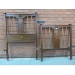 A pair of Arts and Crafts inlaid oak and copper single bed ends