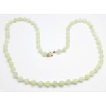 A Chinese jadeite bead necklace with 14k gold clasp
