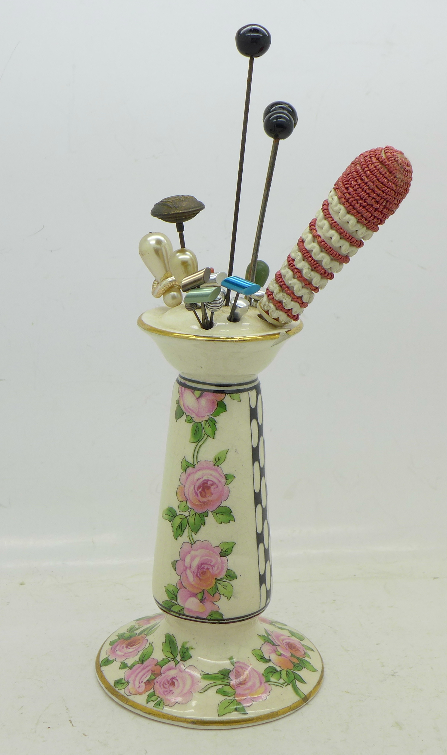 A hat pin holder with a collection of hat pins