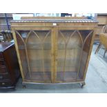 A walnut bow front display cabinet