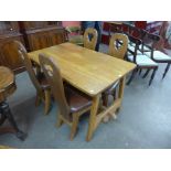 An Arts and Crafts Cotswold School oak refectory table and four chairs