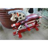 A painted wooden rocking horse and a painted steel rocking horse