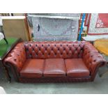 A red leather Chesterfield settee