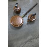 A copper warming pan and two copper kettles
