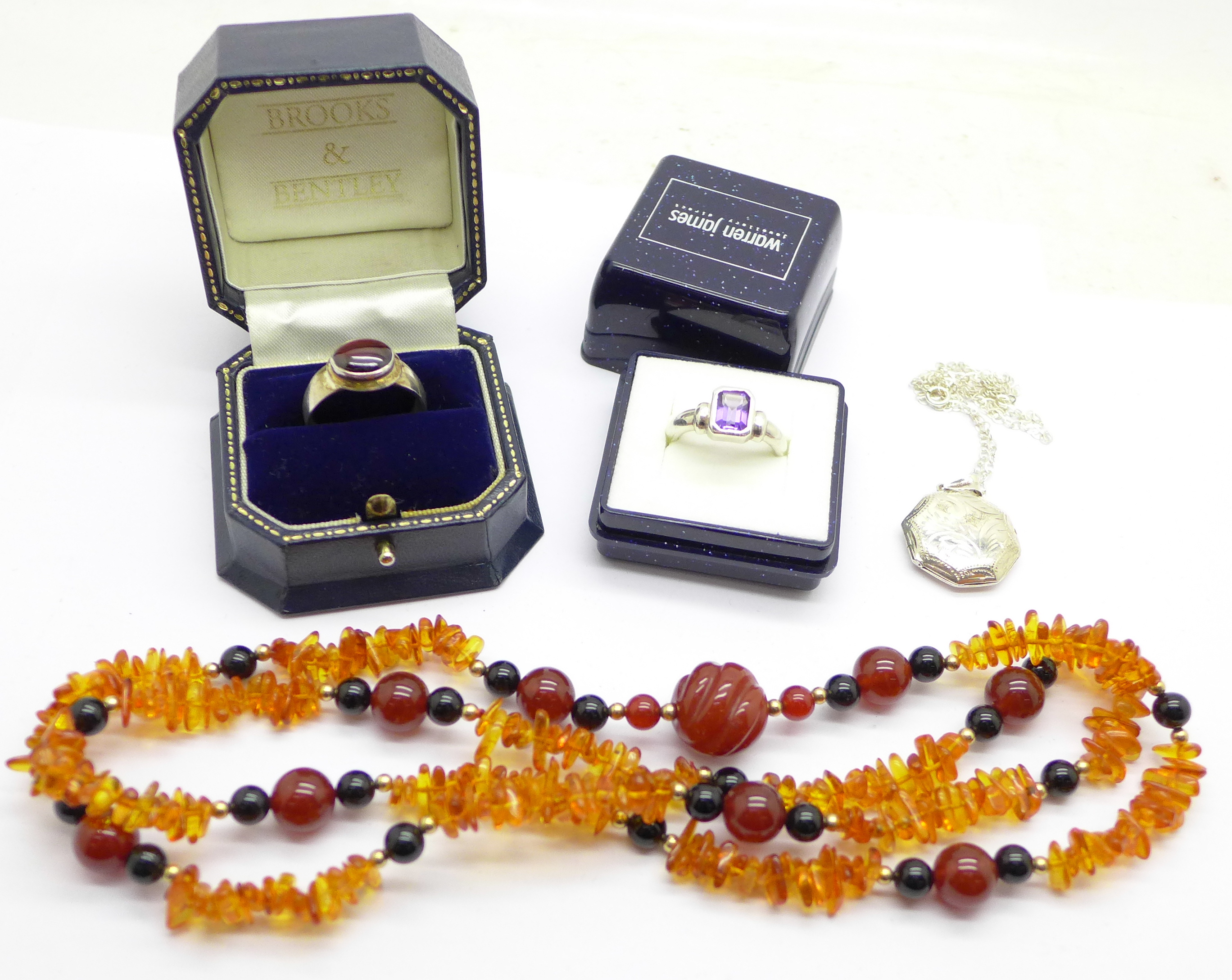 Amber jewellery, a silver locket and chain, two rings,