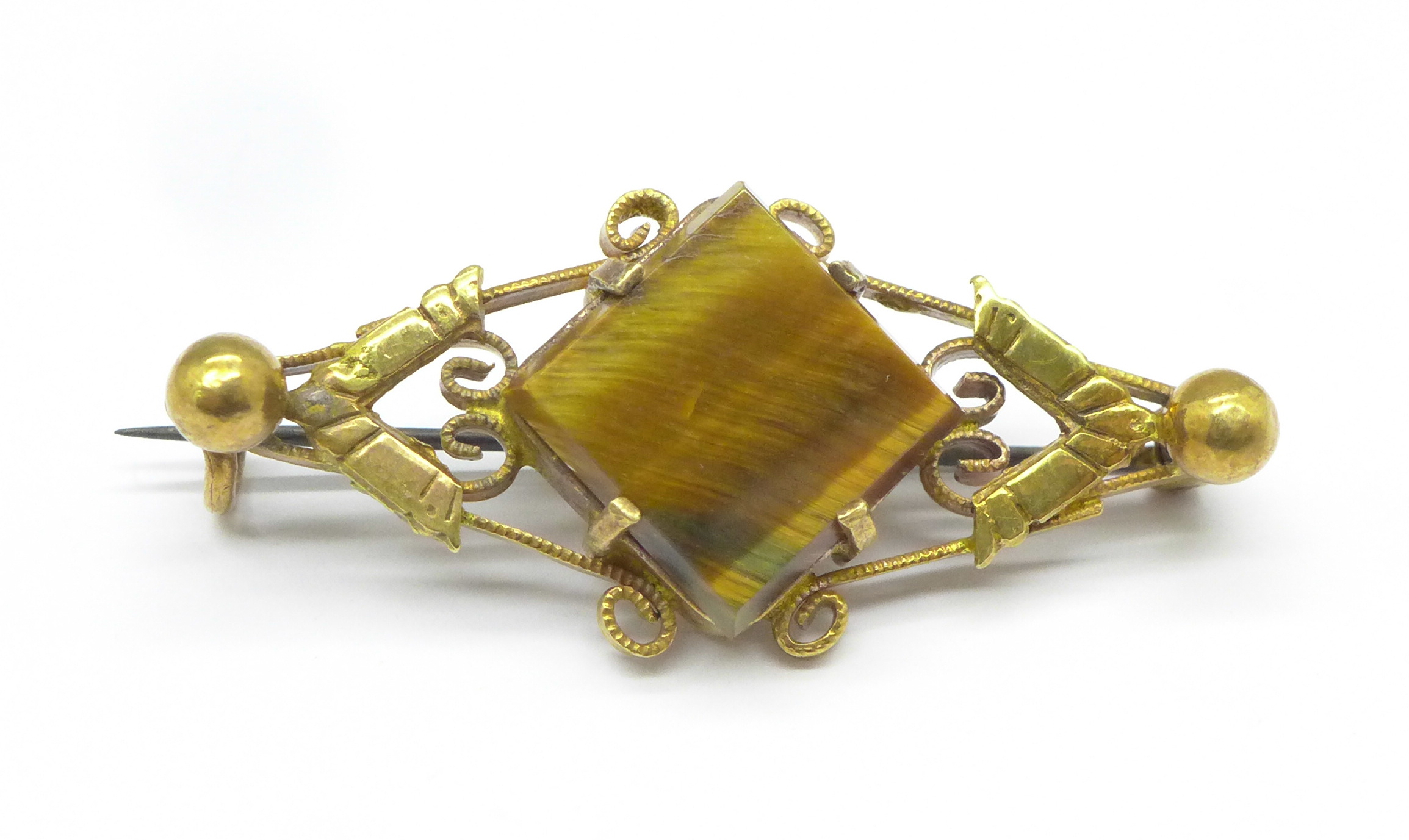 A yellow metal and tigers eye brooch, 4.